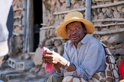 Man in Lesotho sits outside his family home